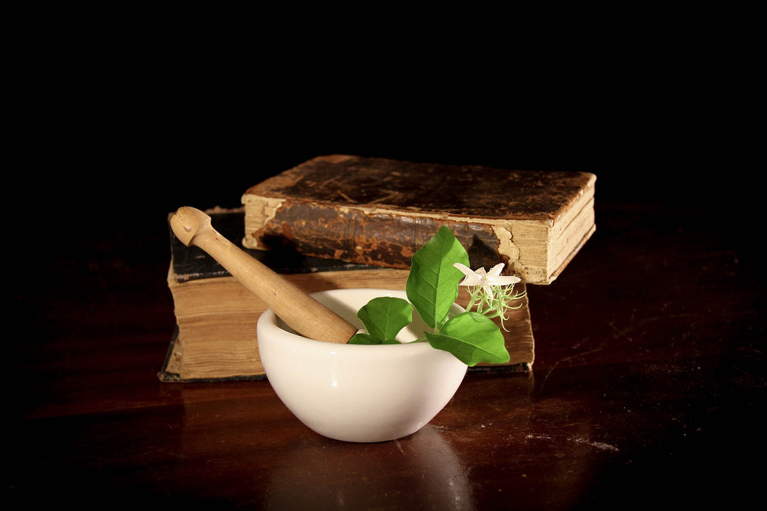 mortar and pestle in front of old books